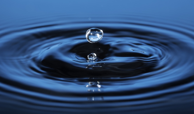 Close-up of drops of water sending ripples out on surface of water